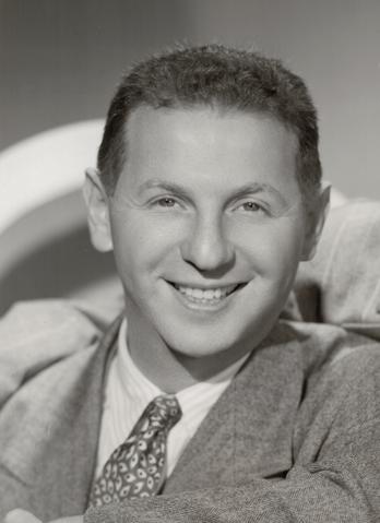 Circa 1940s photo of a smiling young man in a pin-striped suit.

Verso of photo reads: Kindly credit Boris Bakchy Photographyer, 1650 B'way., New York City, circle 5-9622